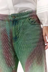 Pantalón de jean wide leg con estampado tie-dye en tonos verde y marrón, con apliques de strass.