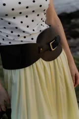 Faja ancha de cuero sintético negro con hebilla dorada y bolsillo lateral.