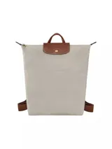 Mochila Longchamp modelo Le Pliage Original en tamaño M, color verde oscuro. Presenta solapa y asas de cuero marrón con cierre de botón a presión, correas ajustables de tela y cierre superior con cremallera.