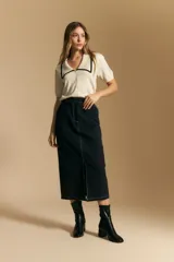 Falda midi negra de denim con costuras blancas contrastantes y tajo frontal.