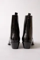 Bota de cuero negro estilo texano, con caña media, elástico lateral con costuras verticales y taco cuadrado.