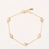 Pulsera dorada con cadena fina y cinco dijes redondos con incrustaciones de circonias. Cuenta con cierre de mosquetón y cadena de extensión.