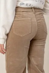 Pantalón de corte recto confeccionado en pana color beige, con bolsillos delanteros tipo parche y cierre frontal con botón.