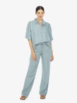 Camisa celeste de manga corta con botones en el frente y un bolsillo en el pecho.