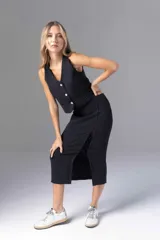 Falda midi negra con finas rayas verticales blancas, corte recto y abertura lateral con cordones cruzados.