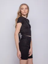 Calza ciclista negra de tela brillante con textura acanalada y elástico en la cintura.