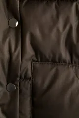 Chaleco acolchado tipo puffer color marrón oscuro, con cuello elevado, cierre frontal oculto por solapa con botones a presión y bolsillos tipo parche en el frente.