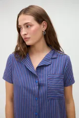 Vestido camisero de algodón con diseño a rayas verticales en tono amarillo claro, cuello solapa y cierre frontal de botones.