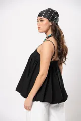 Top negro de diseño versátil con tirantes finos, silueta abombada, elástico en la espalda y hebilla forrada en el frente.