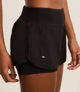 Bermuda deportiva tipo runner, color verde menta, confeccionada en microfibra con cintura elástica. Tiene un corte holgado y bajo redondeado.