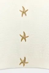 Chaqueta corta de punto texturizado color blanco roto, con escote en V, manga corta y cierre frontal con tres botones metálicos dorados en forma de estrella de mar.