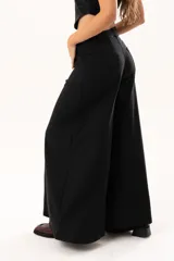 Pantalón de tiro medio con corte súper acampanado, confeccionado en gabardina con spandex. Presenta bolsillos delanteros y traseros, con cierre frontal de cremallera y botón.