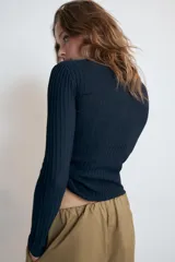 Camiseta rústica de canalé color beige, con cuello redondo y cierre frontal de botones nacarados, de manga larga y ajuste slim fit.