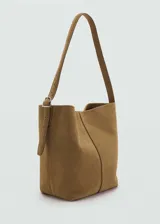 Bolso tipo hobo de cuero gamuzado color marrón, con asa larga ajustable y cierre de botón magnético.