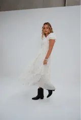 Vestido corto color crema con estampado floral, escote cuadrado con lazo ajustable, mangas cortas abullonadas y corte princesa.