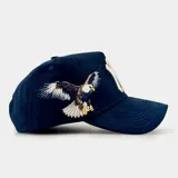 Gorra tipo baseball color azul marino con bordado frontal del logo de los New York Yankees y la inscripción New York en tipografía cursiva. Presenta visera curva y ajuste posterior.