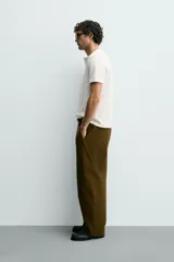 Camiseta de manga corta con cuello panadero y cierre frontal de tres botones. Presenta una textura acanalada y un corte regular fit.