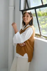 Chaleco de punto color camel, con cuello en V y diseño holgado.