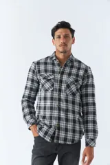 Sobrecamisa de algodón a cuadros color ladrillo, con interior de corderito, cierre con botones, bolsillos tipo cartera y logo en goma. El modelo usa talle M.