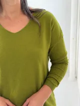 Sweater de punto color verde pistacho, con escote en V, mangas largas y corte holgado.