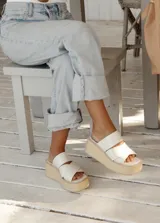 Sandalias con plataforma de yute y tiras cruzadas de charol color marfil.