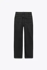 Jeans de tiro alto color negro con efecto lavado, corte mom fit, cinco bolsillos y cierre frontal con cremallera y botón metálico.