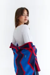 Top de manga larga color marrón, confeccionado en tejido acanalado con cuello bote. Presenta costuras decorativas expuestas a lo largo de las mangas, creando un efecto de relieve.