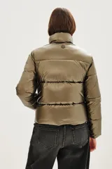 Campera puffer de cuello alto con cierre frontal, acabado metalizado y bolsillos laterales con cierre.