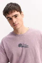 Remera oversize azul marino con efecto lavado, manga corta y cuello redondo. Cuenta con un pequeño estampado gráfico frontal con texto blanco y diseño XL en la espalda.