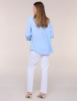 Camisa de lino marca Dash, color beige, con cuello con solapa, escote en V y cierre frontal con botones. Presenta mangas largas regulables con presilla y botón, y un bolsillo aplicado en el pecho.