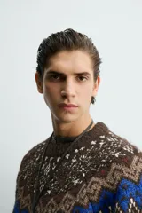Jersey de punto con diseño jacquard geométrico en la parte superior, cuello redondo y manga larga. Presenta un corte relajado con acabados en rib en puños y ruedo.
