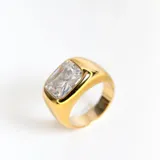 Anillo dorado macizo con cristal claro cuadrado en el frente.