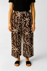 Pantalon de lino con estampado botánico en tonos marrones y beige, de corte holgado y tiro alto.