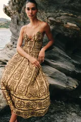 Vestido midi de broderie en tonos mostaza y marrón, con escote en V, tirantes finos ajustables, abertura cut-out en la cintura y espalda con nido de abeja elástico.