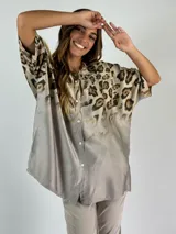 Camisa beige con estampado animal print, de corte amplio y mangas cortas.