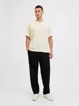 Camiseta de manga corta y cuello redondo, color blanco antiguo (off-white), con un estampado gráfico grande en la espalda que simula una fotografía urbana nocturna con un taxi amarillo y texto en tipografía cursiva y recta.