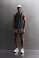 Musculosa deportiva Zara Athleticz de tejido ligero y elástico con paneles laterales de malla transpirable. Presenta cuello redondo, sisas amplias y bajo con aberturas laterales.
