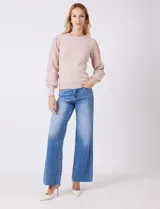 Buzo de tejido lurex marca Nanette, con cuello redondo y mangas largas con diseño plisado. Presenta puños ajustados con aplique de botones decorativos.