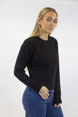 Buzo de punto negro con diseño de trenzas, cuello redondo y mangas largas.
