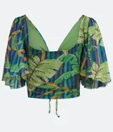 Blusa cropped con estampado de hojas en tonos verdes y azules, escote en V, mangas acampanadas y lazo ajustable en el busto.
