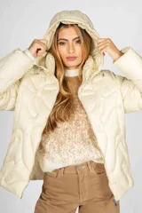 Campera puffer color crudo con diseño acolchado, cierre frontal y capucha. Confeccionada en nylon, presenta un corte moderno y versátil.
