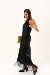 Vestido midi de satén color negro, con escote halter cruzado y ruedo terminado en flecos largos.
