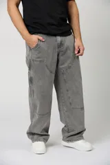 Jean baggy de hombre color gris, con diseño holgado, estilo cargo y parches en las rodillas.