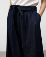 Pantalón de denim azul marino, tiro alto, con pinzas delanteras, canesú trasero y pierna ancha. Incluye cinturón de lazo del mismo tejido.