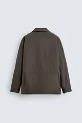 Chaquetón de corte regular fit confeccionado en tejido técnico repelente al agua, con ligero acolchado interior. Presenta cuello solapa, cierre frontal con cremallera oculta por solapa con botones a presión, mangas largas con puños ajustables y múltiples bolsillos de plastrón con solapa en el delantero.