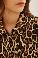 Camisa de corte clásico con cuello camisero y cierre frontal de botones, confeccionada en tela fluida con estampado animal print de leopardo.