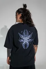 Remera oversize de algodón elastizado en color negro, con diseño gráfico estampado en la espalda que presenta motivos alados y elementos celestiales.