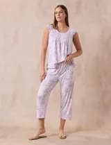Conjunto de pijama marca René Rofé, compuesto por remera de mangas cortas con escote en V abotonado y pantalón capri con cintura elastizada. Diseño estampado con flores azules sobre fondo blanco.