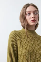 Polera de punto color marrón, con cuello alto y diseño de trenzas verticales en el frente y tejido acanalado en las mangas. Presenta mangas raglán y terminaciones acanaladas en puños y ruedo.