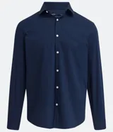 Camisa de vestir blanca de algodón con textura maquinetada, cuello camisero y mangas largas.